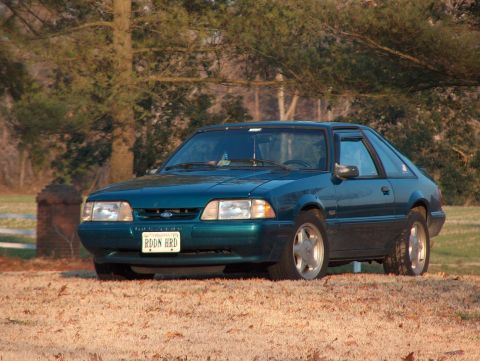 1993 Ford Mustang - Teal green 1993 Ford Mustang coupe with a custom license plate sits on a dry, grassy field.