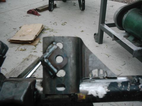 1978 Ford Bronco - A close-up view of a custom-welded metal bracket, likely a vehicle part, on a concrete floor.