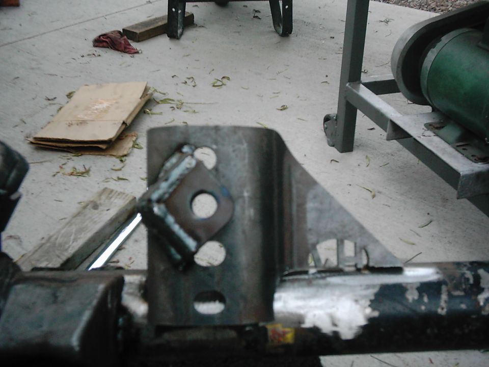 Welded metal bracket with diamond-shaped plate and holes, on a concrete surface