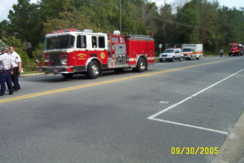 1998 Ford Crown Victoria - A fire truck and other emergency vehicles are lined up on a road.