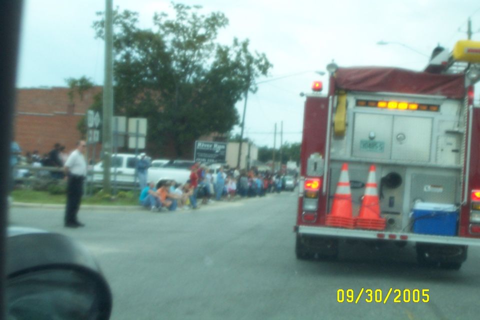 Fire truck with orange cones and a blue cooler on the back, parked on a street with people watching a parade. Date stamp reads 09/30/2005