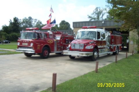 1998 Ford Crown Victoria - Two fire trucks, an older model on the left and a newer model on the right, are parked in front of a fire station. The date stamp indicates…