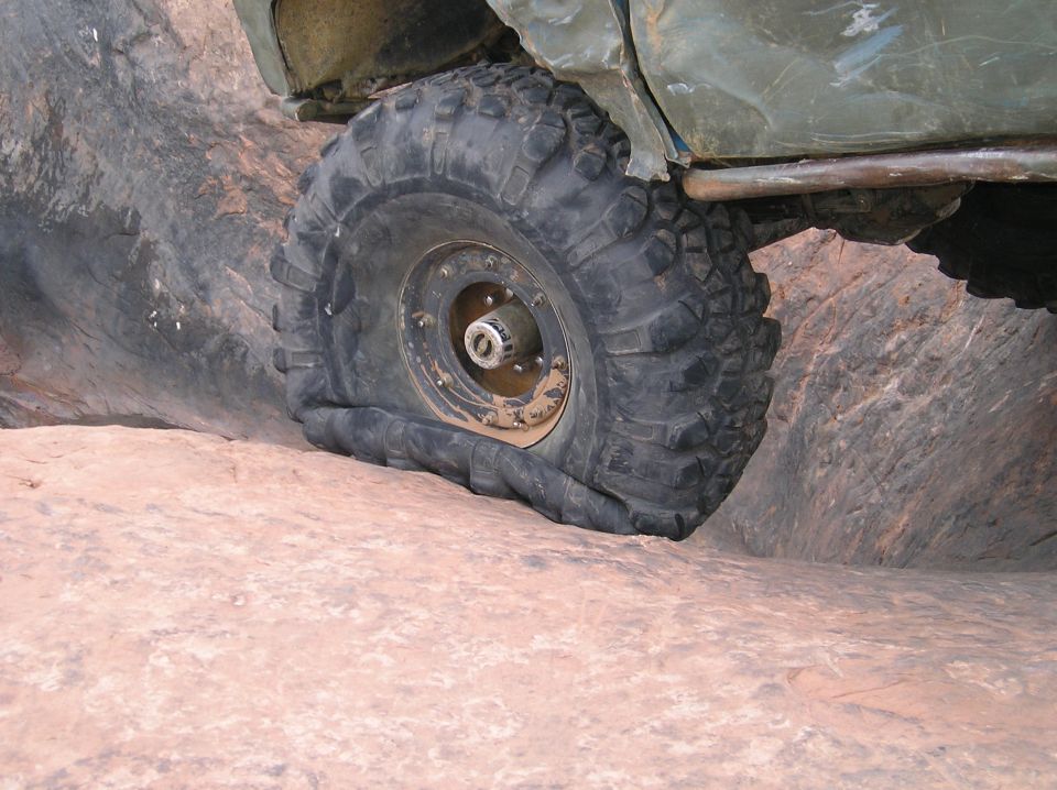 Off-road vehicle tire is flat on a rock surface