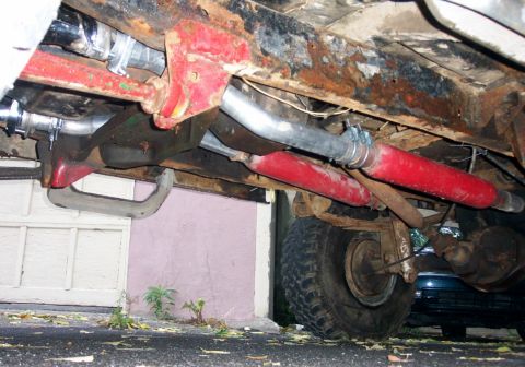 1978 Ford Bronco - Undercarriage view showing red shock absorbers and exhaust system components.