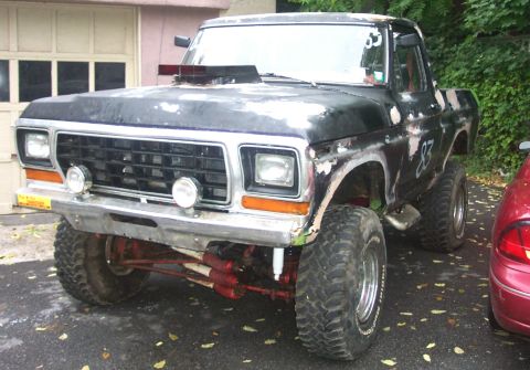 1978 Ford Bronco - This heavily modified pickup truck features a prominent hood scoop and large off-road tires, with the number '83' visible on its side.