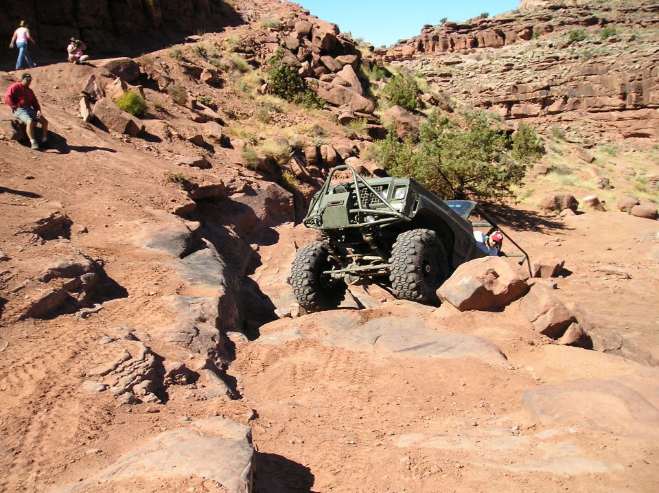 Off-road buggy with roll cage navigating rocky terrain