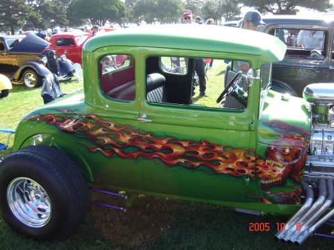 1993 Ford Bronco - A custom green hot rod with flame and skull graphics is displayed at an outdoor event.