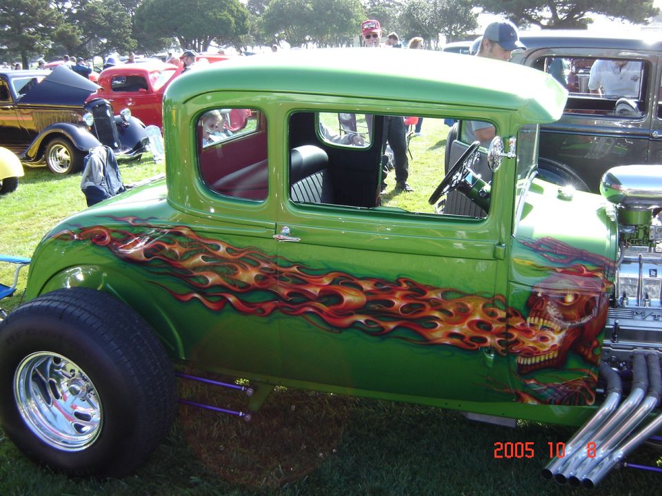 Green hot rod with flame and skull graphics, side view