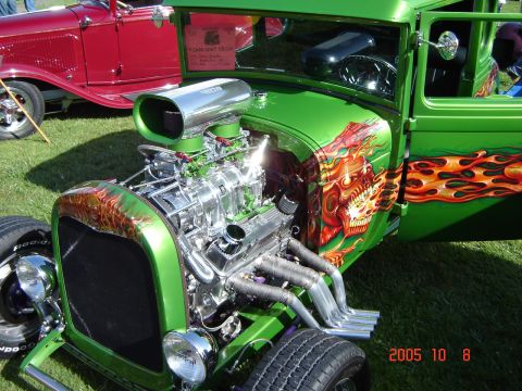 1993 Ford Bronco - Custom hot rod with skull and flame graphics parked next to a red vintage car.