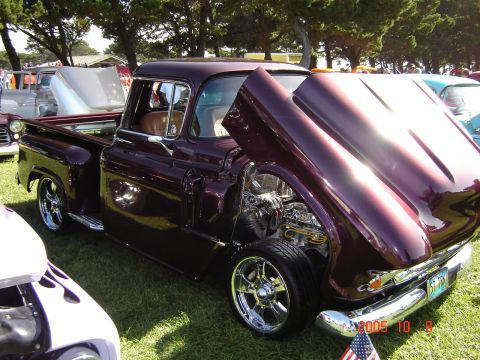 1993 Ford Bronco - Customized 1955 Chevrolet pickup truck with engine exposed at an outdoor car show.