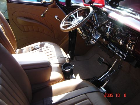 1993 Ford Bronco - The interior of a classic car shows tan upholstery, a chrome steering wheel, and a detailed dashboard.