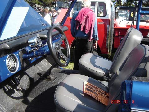 1993 Ford Bronco - The interior of a 1993 Ford Bronco, custom gauges and an aftermarket steering wheel, is shown at a car show.