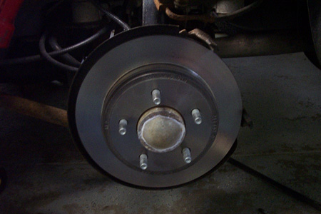 1999 Chrysler 300M - Close-up view of a disk brake rotor, showing the hub and lug nut mounting points.