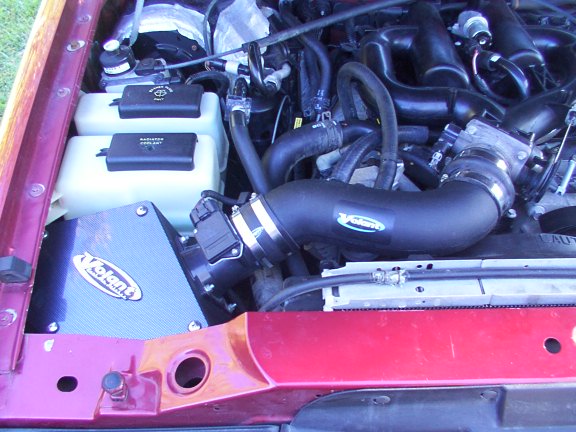 Engine bay with Volant cold air intake and black intake tube in a maroon vehicle