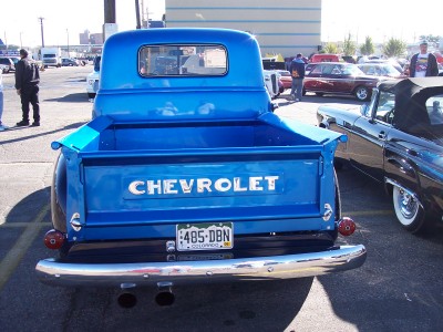 1972 Ford Ranchero - A bright blue Chevrolet pickup truck is parked next to a black convertible.