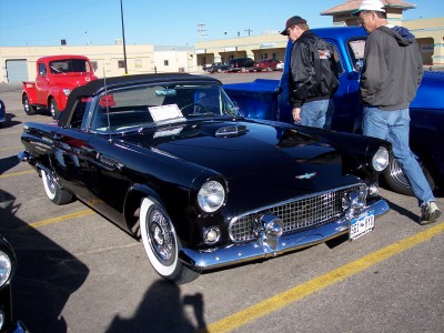 1972 Ford Ranchero - A black 1955 Ford Thunderbird convertible is parked next to a blue pickup truck.