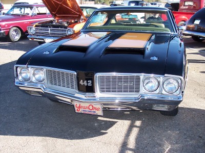 1972 Ford Ranchero - Black 1970 Oldsmobile 442 with distinctive grille and hood scoops, parked outdoors.