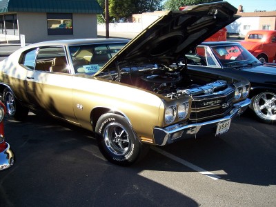 1972 Ford Ranchero - Gold 1970 Chevrolet Chevelle SS, hood up, parked outdoors with another vehicle beside it.
