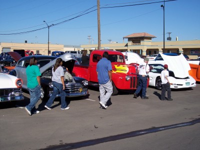 1972 Ford Ranchero - A red pickup truck with flame decals is displayed at an outdoor event with other vehicles.