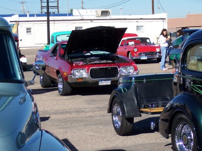 1972 Ford Ranchero - A red 1972 Ford Ranchero is parked with its hood open, surrounded by other vehicles.