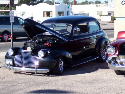 1972 Ford Ranchero - Black sedan from the 1940s with its hood open, parked beside another vehicle.