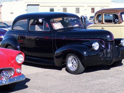 1972 Ford Ranchero - Black sedan with red trim parked at an outdoor event with other classic cars.