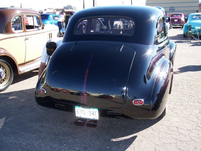 1972 Ford Ranchero - A black coupe with custom pinstriping and dual exhaust pipes is parked at an outdoor event.