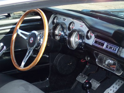 1972 Ford Ranchero - The interior of a classic car features a wood-rimmed steering wheel and a dashboard with prominent gauges.