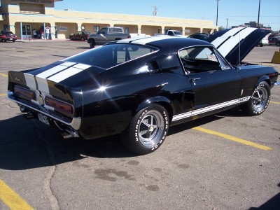 1972 Ford Ranchero - A black 1968 Ford Mustang Shelby GT500KR with white racing stripes is parked with its hood up.