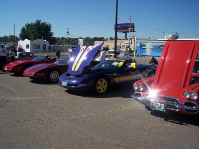 1972 Ford Ranchero - Several Corvettes are lined up with their hoods open on a sunny day.