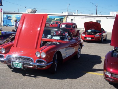 1972 Ford Ranchero - A red 1958 Chevrolet Corvette convertible is parked with its hood open, alongside other vehicles.