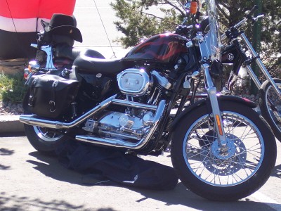 1972 Ford Ranchero - A motorcycle with saddlebags and a cowboy hat is parked next to another motorcycle.