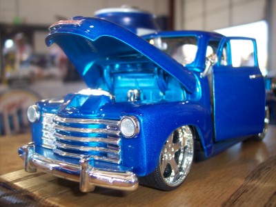 1972 Ford Ranchero - Model pickup truck with custom paint and open hood sits on a wooden surface.