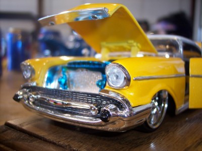 1972 Ford Ranchero - A close-up of a yellow toy car model with its hood and driver's side door open.