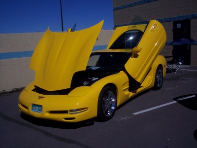 1972 Ford Ranchero - A bright yellow sports car is displayed with its hood and butterfly doors open, revealing the engine compartment.