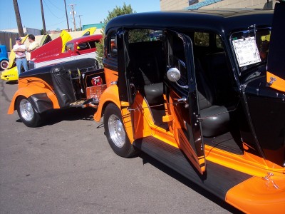 1972 Ford Ranchero - A custom hot rod sedan and trailer are parked on a street, with other vehicles nearby.