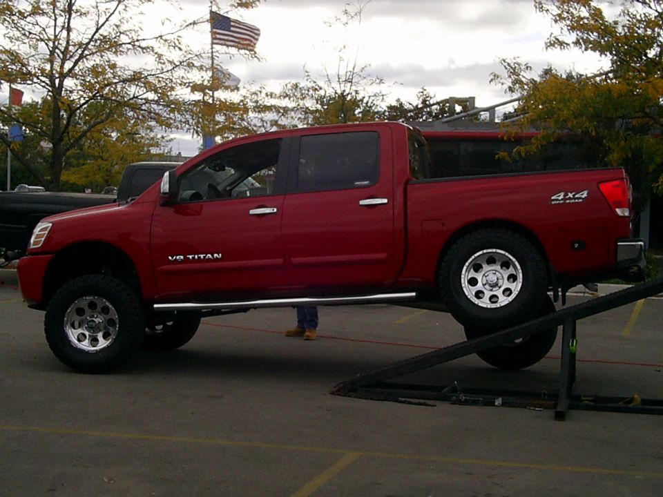 Red pickup truck with V8 TITAN badging and 4x4 emblem