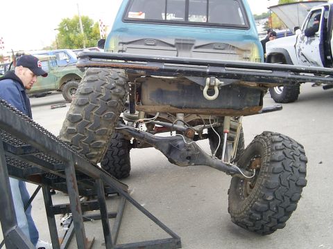 1985 Ford Bronco - Rear view of a heavily modified off-road truck's suspension and axle assembly.