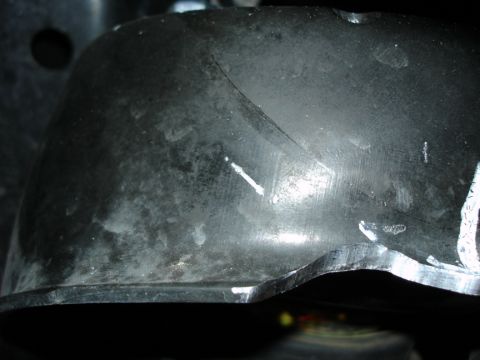 2005 Nissan Titan - This image shows a close-up of a modified suspension component with visible cut marks and wear.