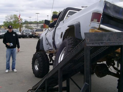 1985 Ford Bronco - A heavily modified pickup truck is positioned on a ramp, with a person standing beside it.