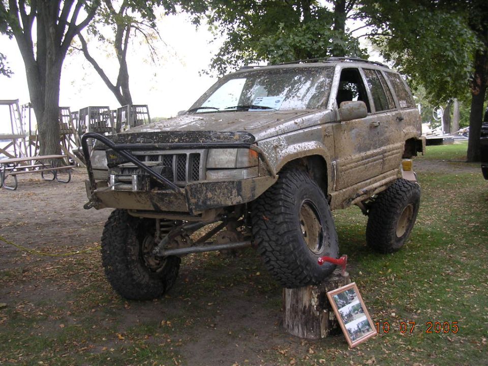 1995 Jeep Grand Cherokee, mud-covered, lifted, with off-road tires and brush guard