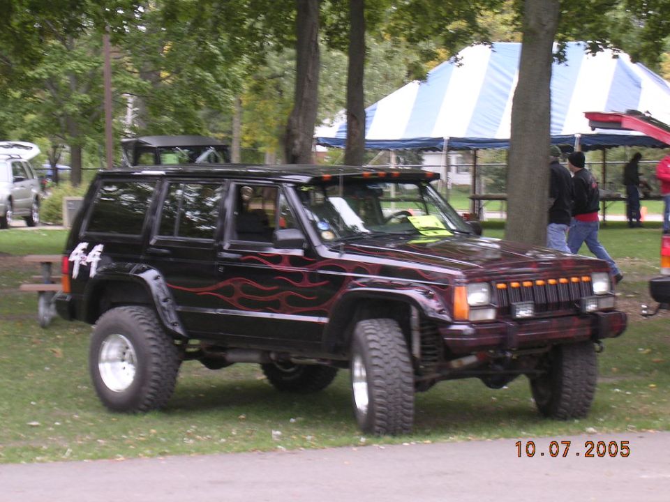 Black Jeep Cherokee with red flames on the side and "44" on the rear fender