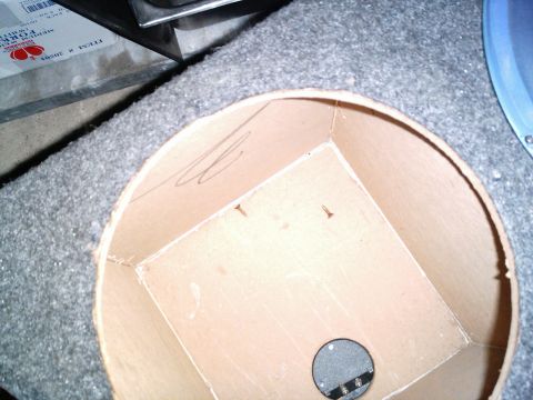 1986 Ford Bronco - A shop-built MDF speaker enclosure sits face-down on gray automotive carpet, its round baffle cutout revealing square internal bracing and…