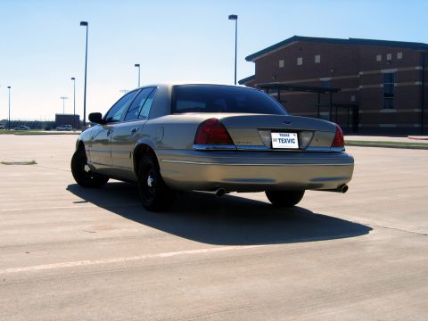 2000 Ford Crown Victoria - Rear view of a gold 2000 Ford Crown Victoria sedan parked in a lot.