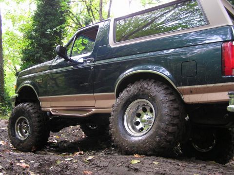 1995 Ford Bronco - This lifted 1995 Ford Bronco is shown off-road in a wooded area.