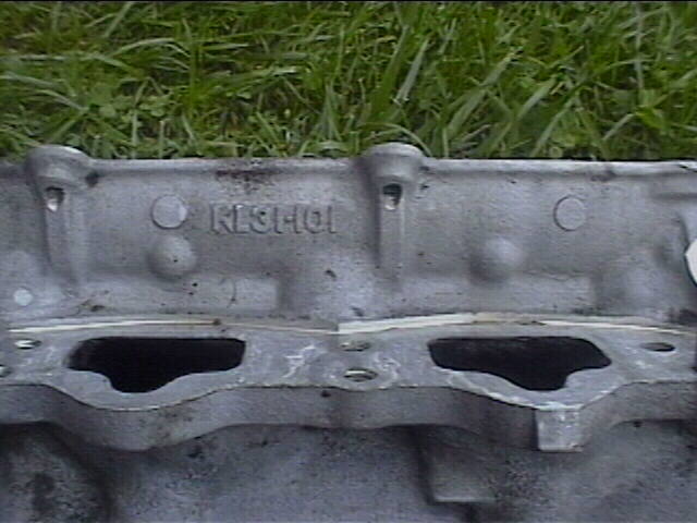 Close-up of a cast metal engine part with 'NISHIOI' stamped on it