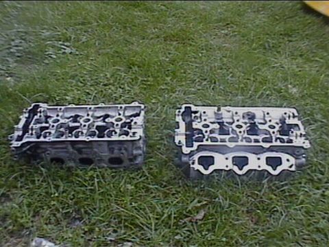 1994 Ford Probe - Two engine cylinder heads are shown resting on a grassy surface.