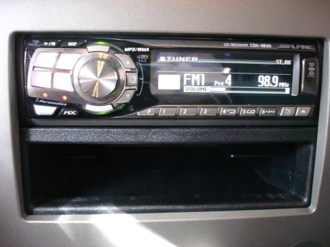 2005 Nissan Titan - Close-up of an aftermarket Alpine car stereo unit installed in a vehicle's dashboard.