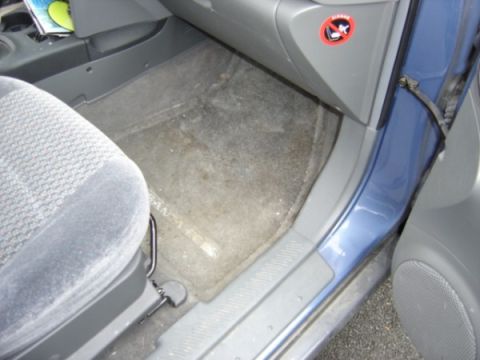 1999 Ford Taurus - The interior of a car shows a blue door and grey seating with a "no smoking" sticker on the dashboard.