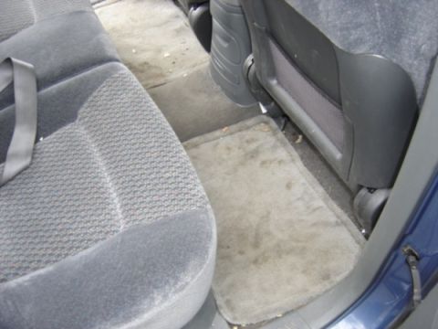 1999 Ford Taurus - The interior of a 1999 Ford Taurus shows worn rear seats and floor mats.